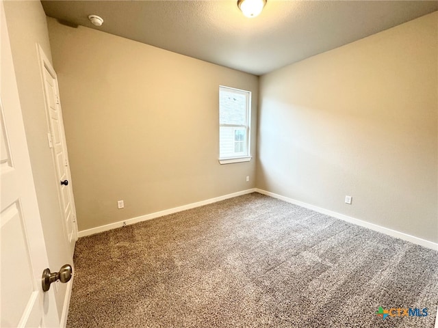 unfurnished room featuring carpet and a textured ceiling