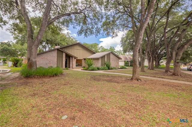 105 Creekside Dr, Victoria, TX 77904 - mid-century inspired home with a chimney and a front lawn