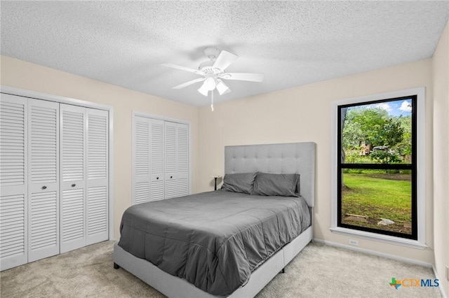 105 Creekside Dr, Victoria, TX 77904 - carpeted bedroom with multiple closets, a textured ceiling, and a ceiling fan