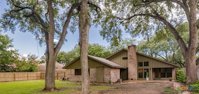 105 Creekside Dr, Victoria, TX 77904 - rear view of property featuring a chimney, brick siding, and board and batten siding
