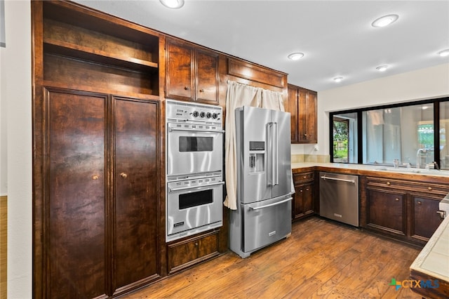 105 Creekside Dr, Victoria, TX 77904 - kitchen with stainless steel appliances, dark wood-type flooring, light countertops, dark brown cabinetry, and recessed lighting