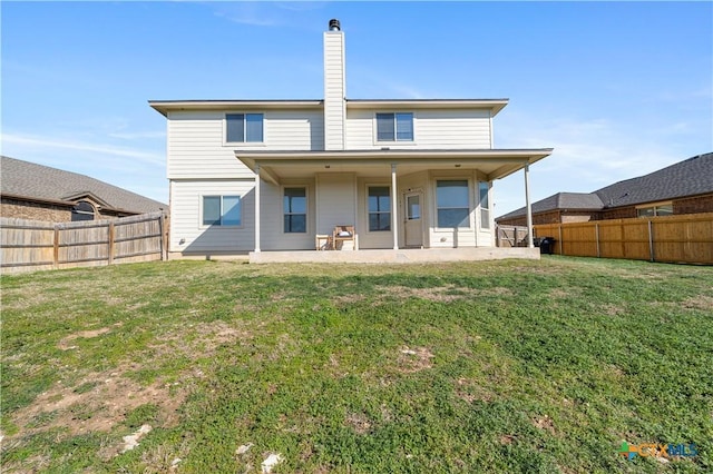 rear view of property with a yard, a patio area, and a fenced backyard