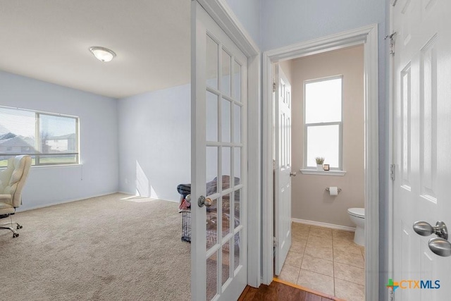 office area with baseboards, carpet floors, french doors, and tile patterned floors