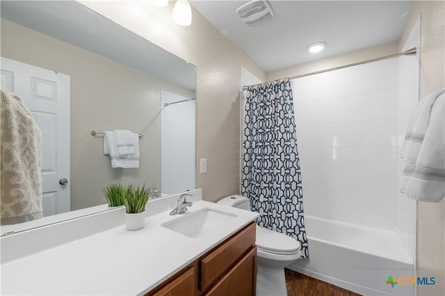 full bath featuring toilet, shower / tub combo, wood finished floors, vanity, and visible vents