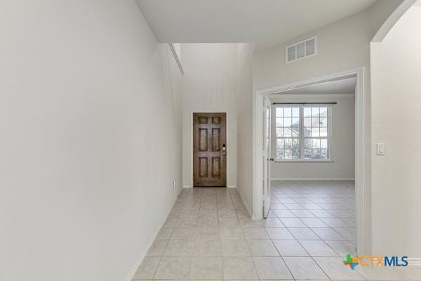 entryway featuring baseboards, visible vents, and light tile patterned flooring