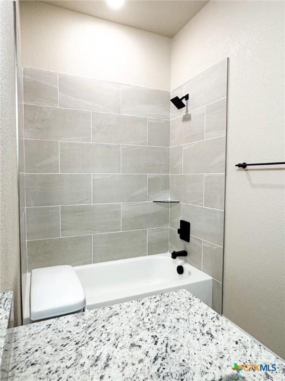 bathroom featuring shower / bathing tub combination and toilet