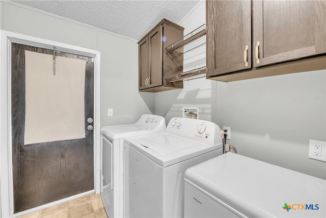 laundry area featuring cabinets, washing machine and dryer, and a textured ceiling