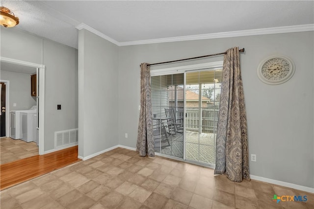 spare room with crown molding and washing machine and dryer