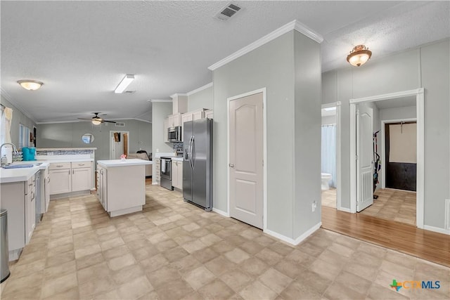 kitchen with white cabinetry, sink, ornamental molding, a center island, and stainless steel appliances