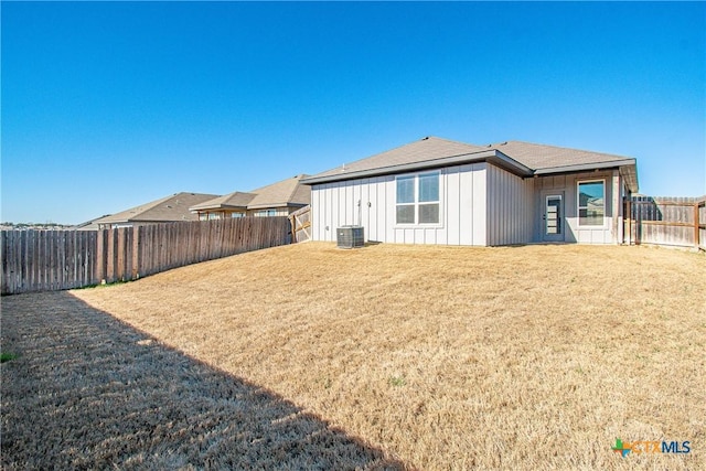 back of property featuring central AC unit and a lawn