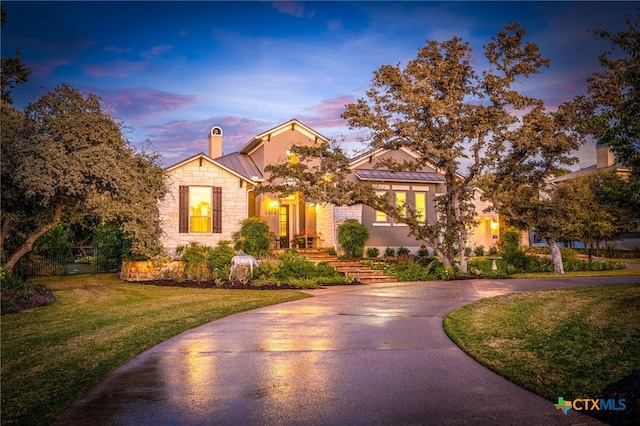 2319 Geneseo Oaks, New Braunfels, TX 78132 - view of front facade with a standing seam roof, curved driveway, a chimney, a lawn, and metal roof