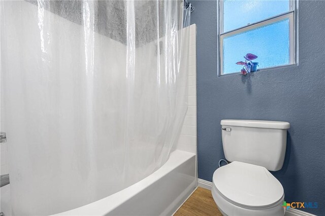 3410 Regency Ct, Killeen, TX 76549 - full bathroom with wood finished floors, baseboards, toilet, a textured wall, and shower / bath combo with shower curtain