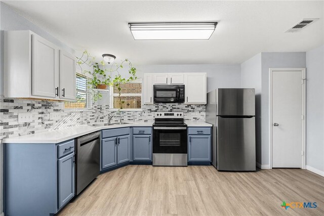 3410 Regency Ct, Killeen, TX 76549 - kitchen with appliances with stainless steel finishes, a sink, light wood-type flooring, decorative backsplash, and light countertops