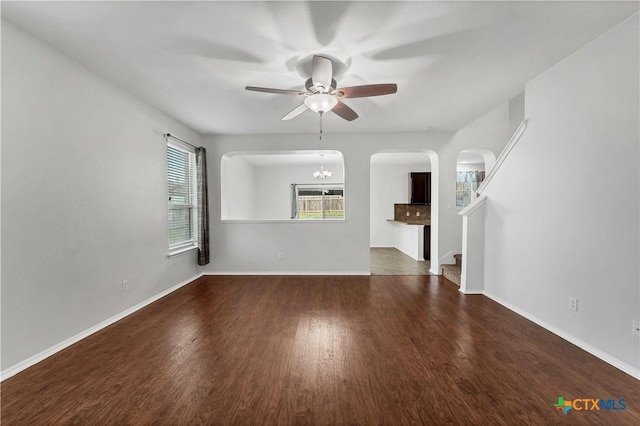 111 Sheep Trail Dr, Kyle, TX 78640 - unfurnished living room featuring wood finished floors, ceiling fan, baseboards, and arched walkways