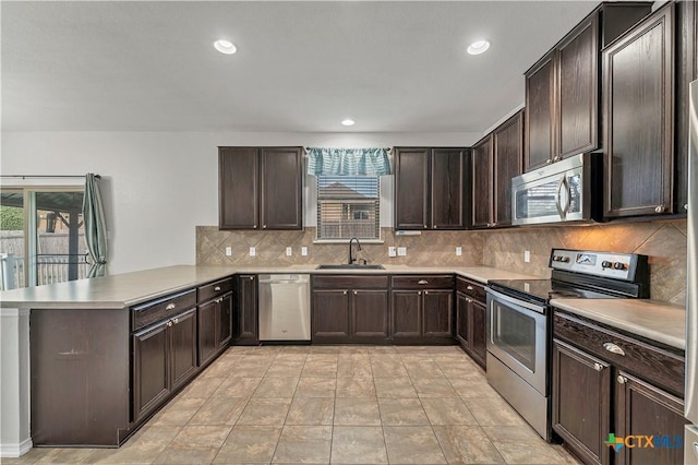 111 Sheep Trail Dr, Kyle, TX 78640 - kitchen with a peninsula, a sink, appliances with stainless steel finishes, and a wealth of natural light