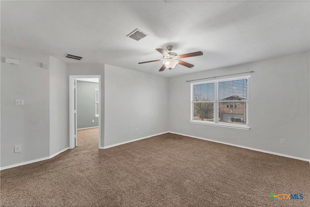 111 Sheep Trail Dr, Kyle, TX 78640 - empty room with baseboards, visible vents, dark carpet, and ceiling fan