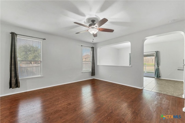 111 Sheep Trail Dr, Kyle, TX 78640 - empty room featuring wood finished floors, a ceiling fan, arched walkways, and baseboards