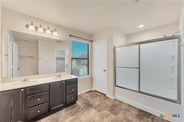111 Sheep Trail Dr, Kyle, TX 78640 - bathroom with double vanity, a sink, enclosed tub / shower combo, and baseboards