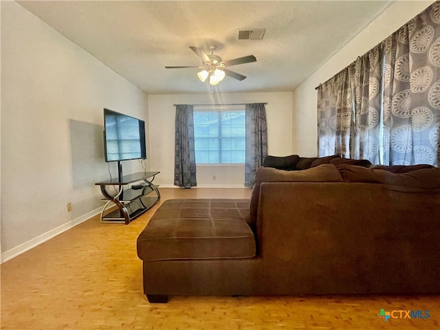 living room featuring a textured ceiling and ceiling fan