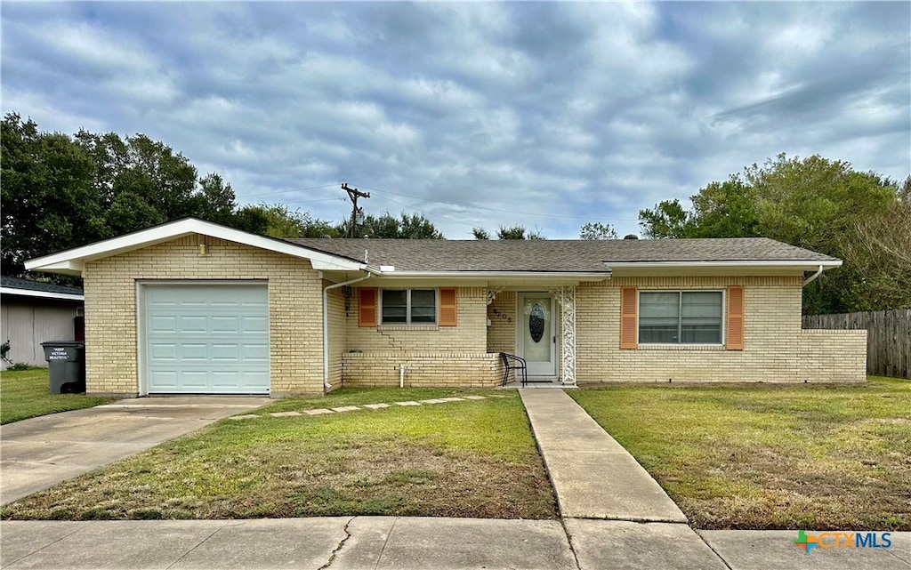 ranch-style house with a garage and a front lawn