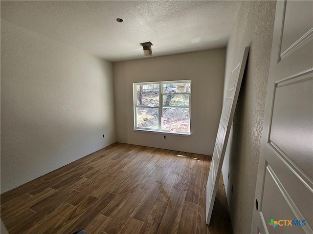 1645 Pecan Cir, Canyon Lake, TX 78133 - unfurnished room featuring wood finished floors, a textured wall, and a textured ceiling