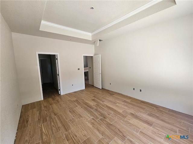 1645 Pecan Cir, Canyon Lake, TX 78133 - unfurnished bedroom featuring a tray ceiling and light wood-style flooring