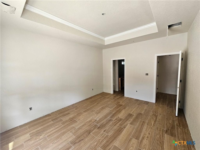 1645 Pecan Cir, Canyon Lake, TX 78133 - unfurnished bedroom featuring a tray ceiling, light wood-type flooring, and crown molding