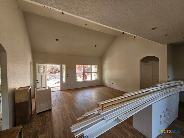 1645 Pecan Cir, Canyon Lake, TX 78133 - hallway featuring arched walkways, wood finished floors, high vaulted ceiling, and a textured ceiling