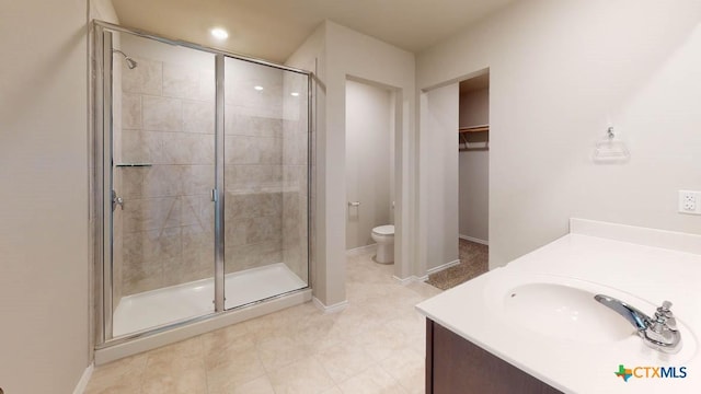 bathroom with walk in shower, vanity, and toilet