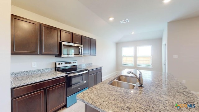 kitchen with stainless steel appliances, sink, and light stone counters