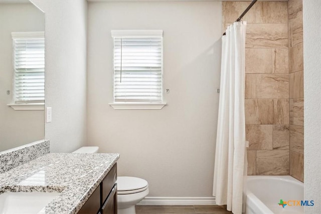 full bathroom featuring vanity, wood finished floors, baseboards, shower / bath combo with shower curtain, and toilet