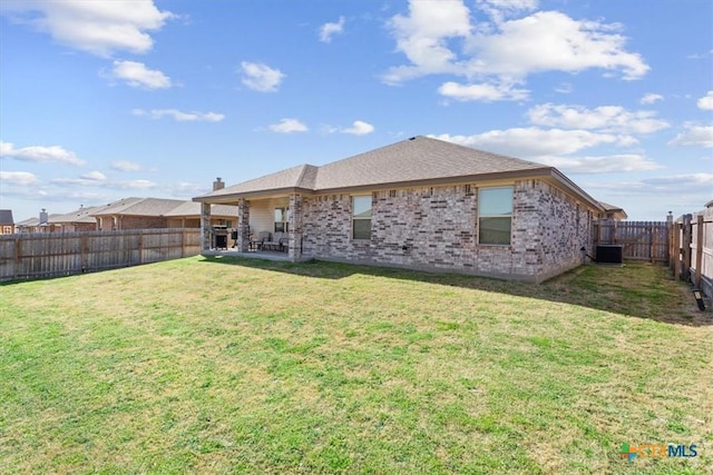 back of property featuring brick siding, central air condition unit, a lawn, and a fenced backyard