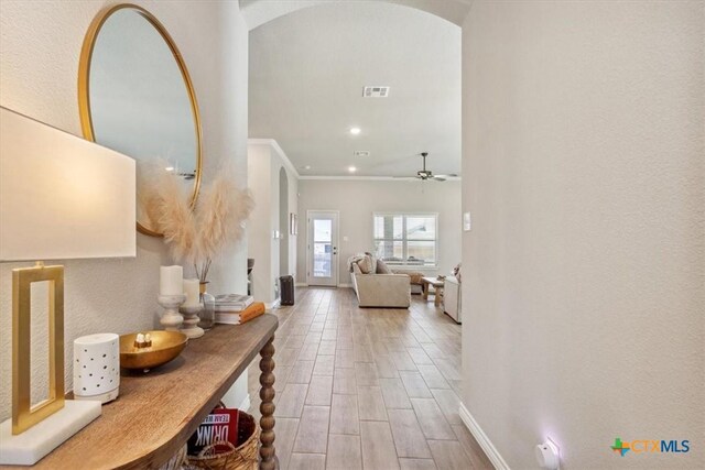 hall featuring visible vents, wood finished floors, recessed lighting, arched walkways, and crown molding