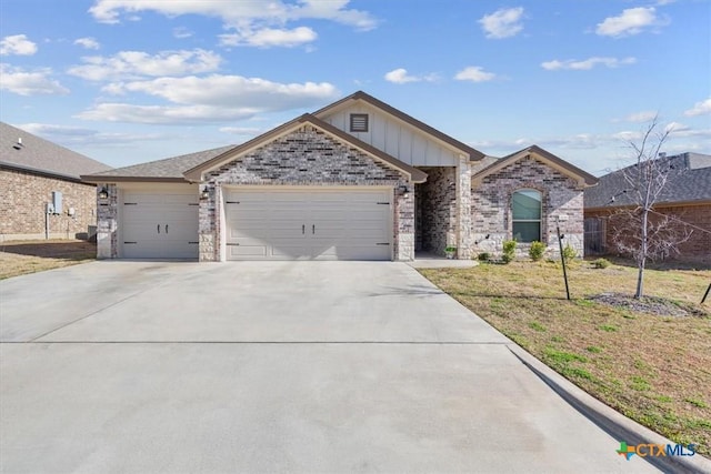 ranch-style house featuring driveway, board and batten siding, a front yard, an attached garage, and brick siding