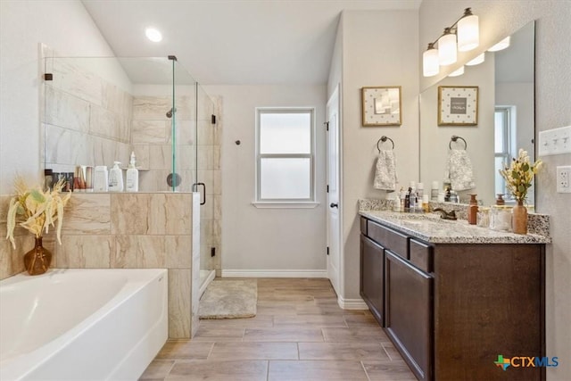 bathroom featuring baseboards, lofted ceiling, a stall shower, a bath, and vanity