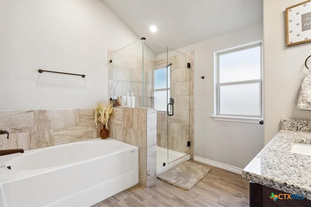 bathroom with vanity, wood finished floors, baseboards, a stall shower, and a bath