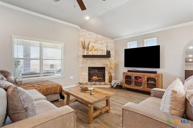 living room featuring crown molding, light wood-type flooring, ceiling fan, and vaulted ceiling