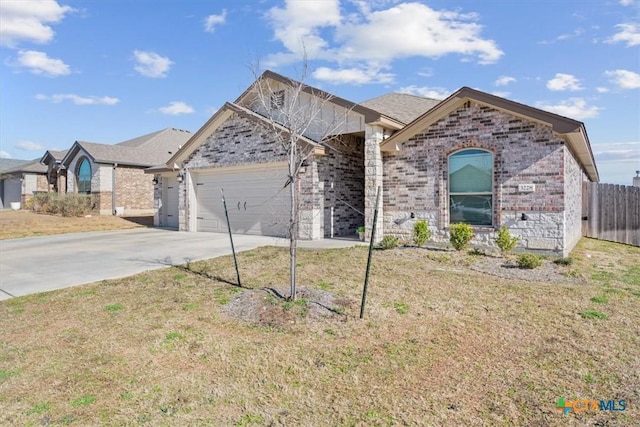 view of front facade featuring a front yard, fence, driveway, a garage, and brick siding