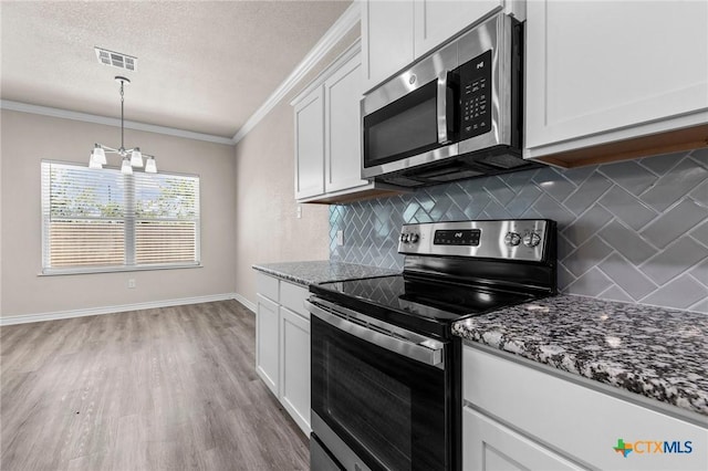 kitchen with tasteful backsplash, a notable chandelier, dark stone counters, white cabinets, and appliances with stainless steel finishes