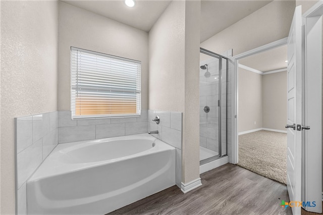 bathroom with hardwood / wood-style floors, ornamental molding, and independent shower and bath