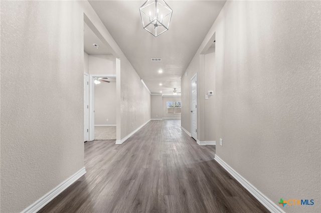 hall with a chandelier and dark hardwood / wood-style flooring