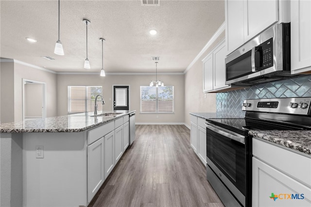 kitchen featuring a center island with sink, sink, a textured ceiling, white cabinetry, and stainless steel appliances