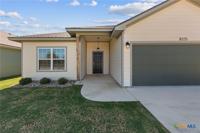 property entrance featuring a garage and a yard