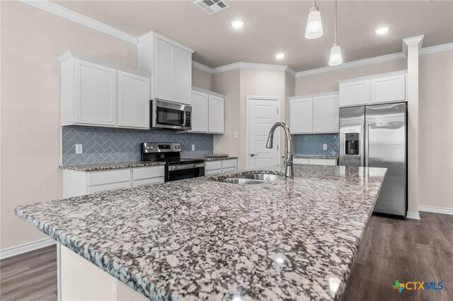 kitchen with a kitchen island with sink, sink, white cabinets, and appliances with stainless steel finishes