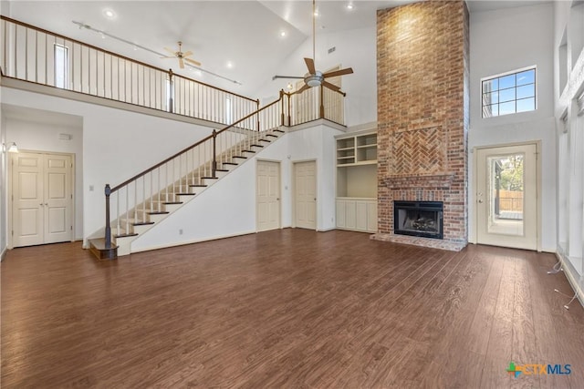 3614 Quail Hollow Rd, Harker Heights, TX 76548 - unfurnished living room with a ceiling fan, high vaulted ceiling, wood finished floors, a fireplace, and stairs
