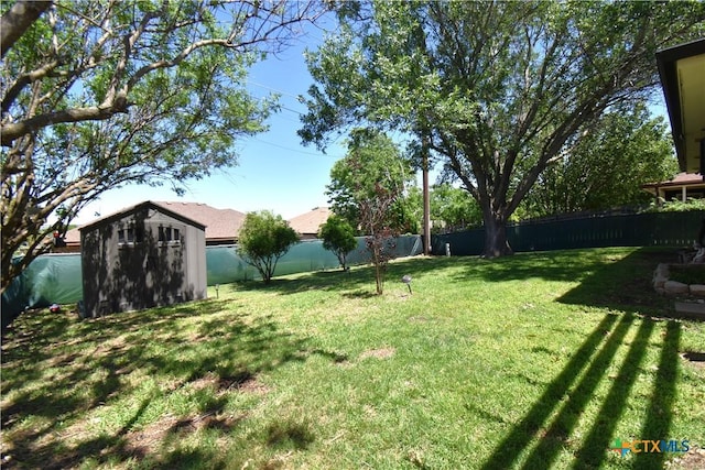 view of yard featuring a fenced backyard, an outbuilding, and a shed