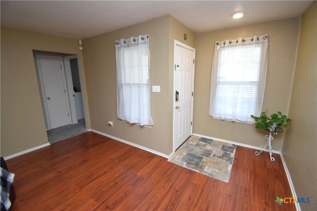 foyer featuring baseboards and wood finished floors