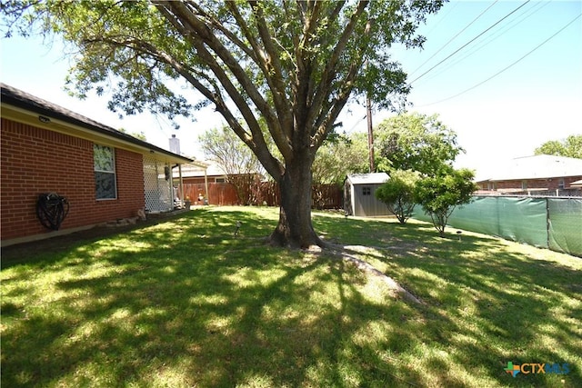 view of yard with a fenced backyard, an outbuilding, and a storage shed