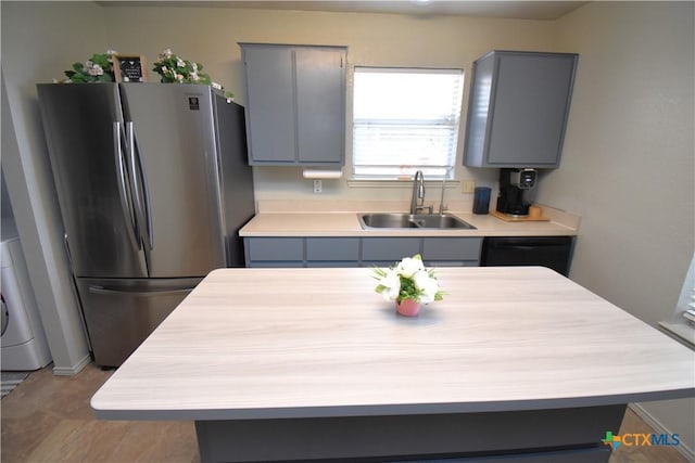 kitchen featuring freestanding refrigerator, gray cabinetry, and a sink