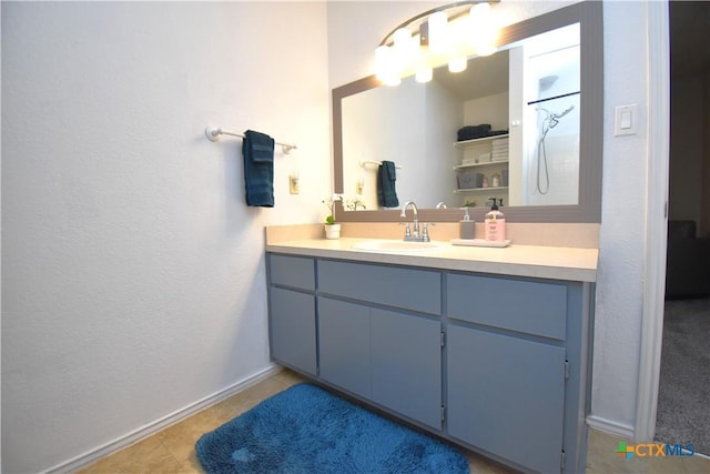 bathroom featuring baseboards, a textured wall, vanity, and tile patterned floors
